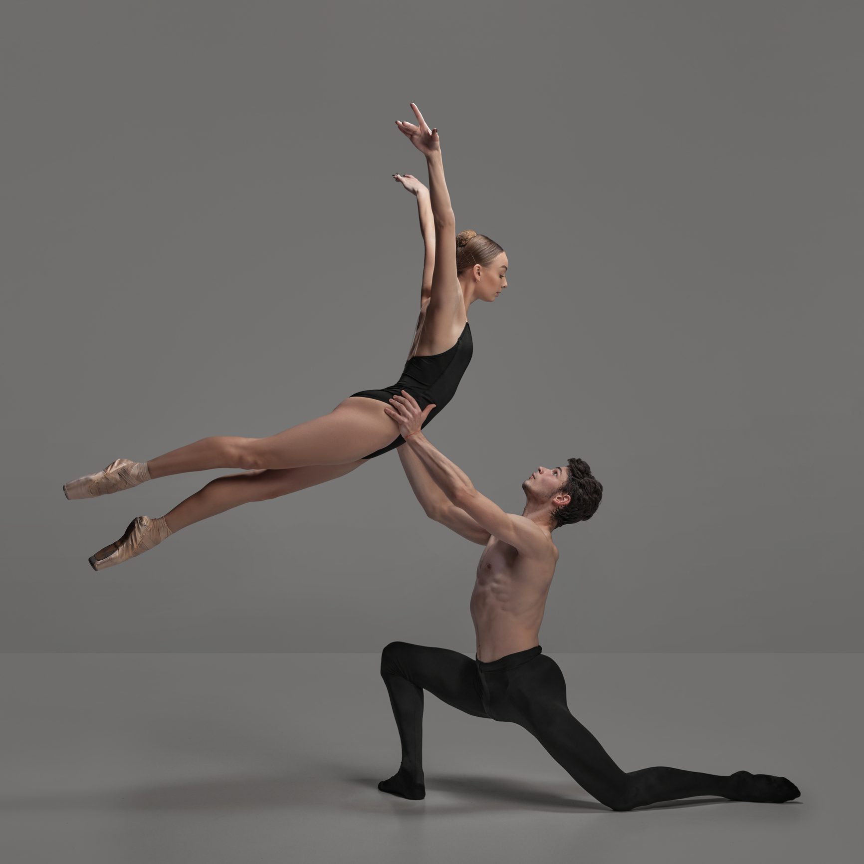 Ballet dancers performing an elegant lift pose.