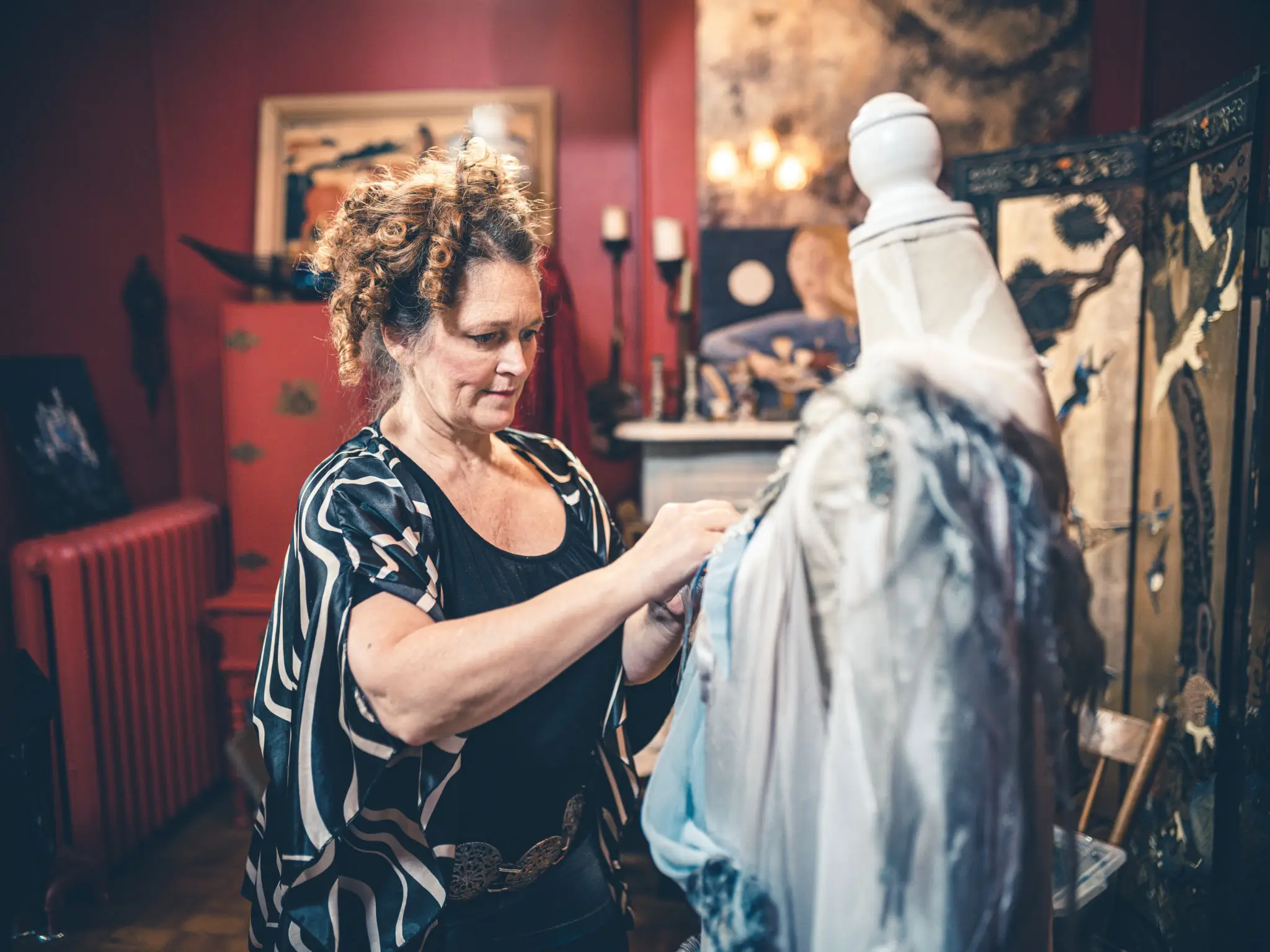 Woman designing clothes on dress form.